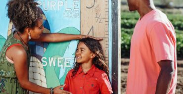 ARFID Family enjoys a sunny day measuring child's height at a corn field.