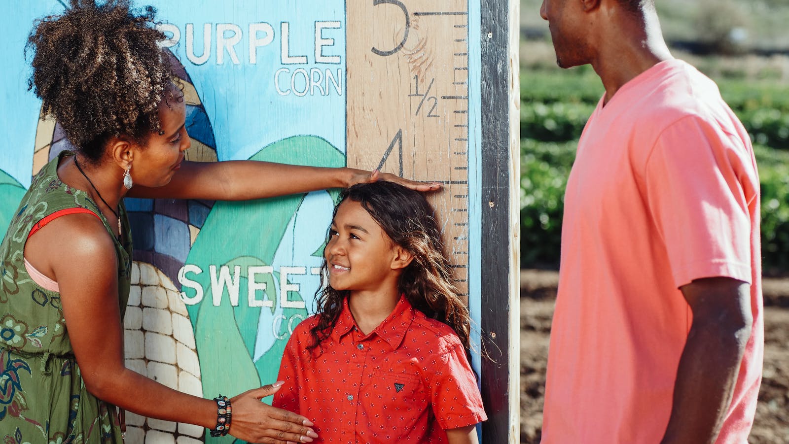 ARFID Family enjoys a sunny day measuring child's height at a corn field.