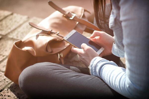 Woman with smartphone using digital intervention in sunlight.