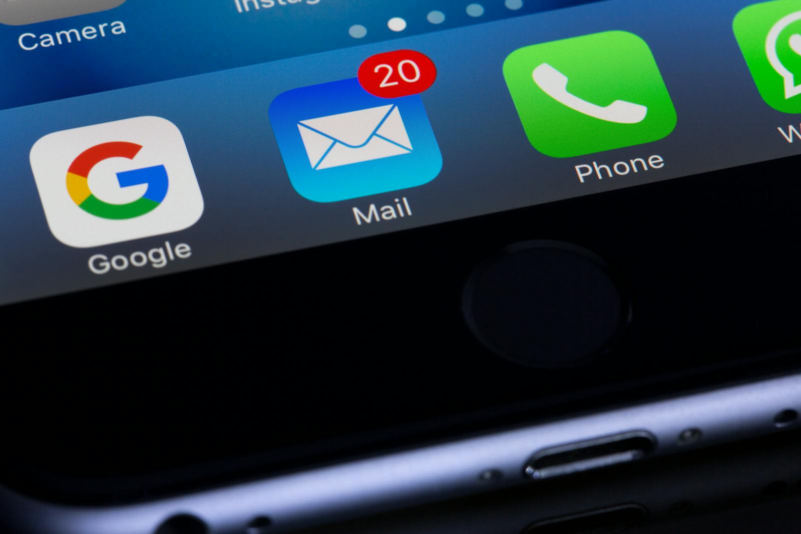 Contacts Us | A close-up photo of a smartphone displaying popular apps like Google and Mail.