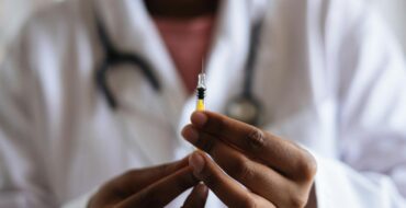 Close-up of a healthcare professional holding a syringe, symbolizing medical care and vaccination. ketamine